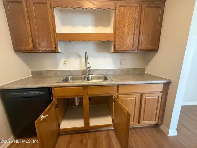 a kitchen with stainless steel appliances granite countertop a sink a stove and a microwave oven with wooden floor