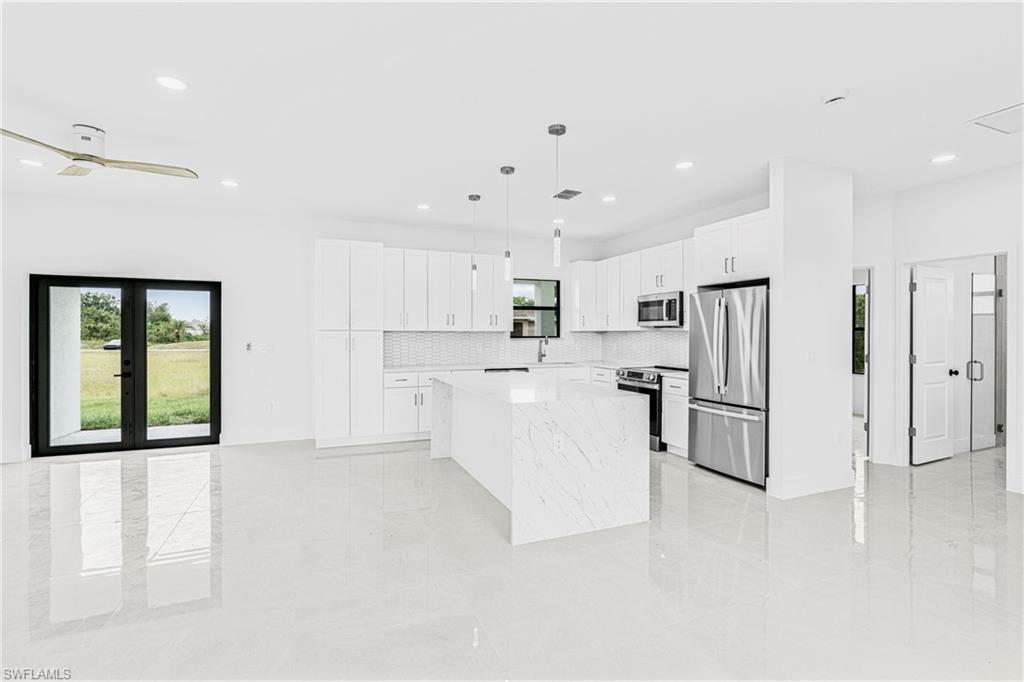 343 Pullman Street Lehigh Acres, FL 33974 - Photo 12 of 43 a view of kitchen with stainless steel appliances refrigerator oven and white cabinets