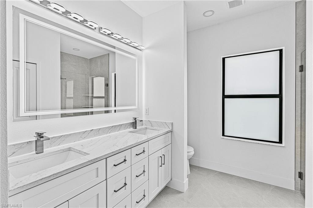 343 Pullman Street Lehigh Acres, FL 33974 - Photo 18 of 43 a bathroom with a double vanity sink and a mirror