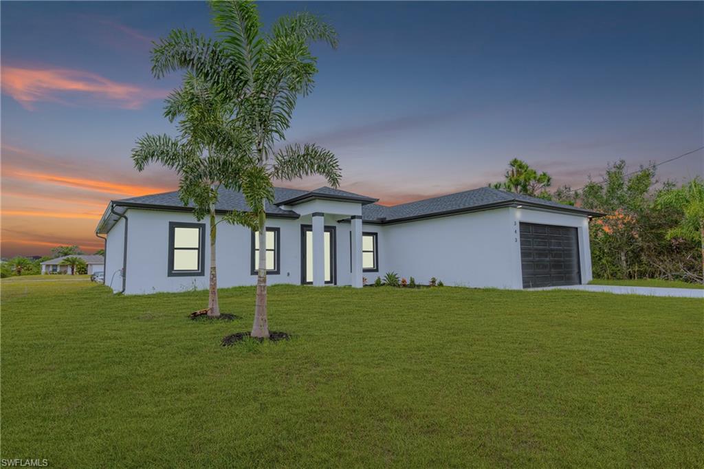 343 Pullman Street Lehigh Acres, FL 33974 - Photo 2 of 43 a front view of a house with a yard