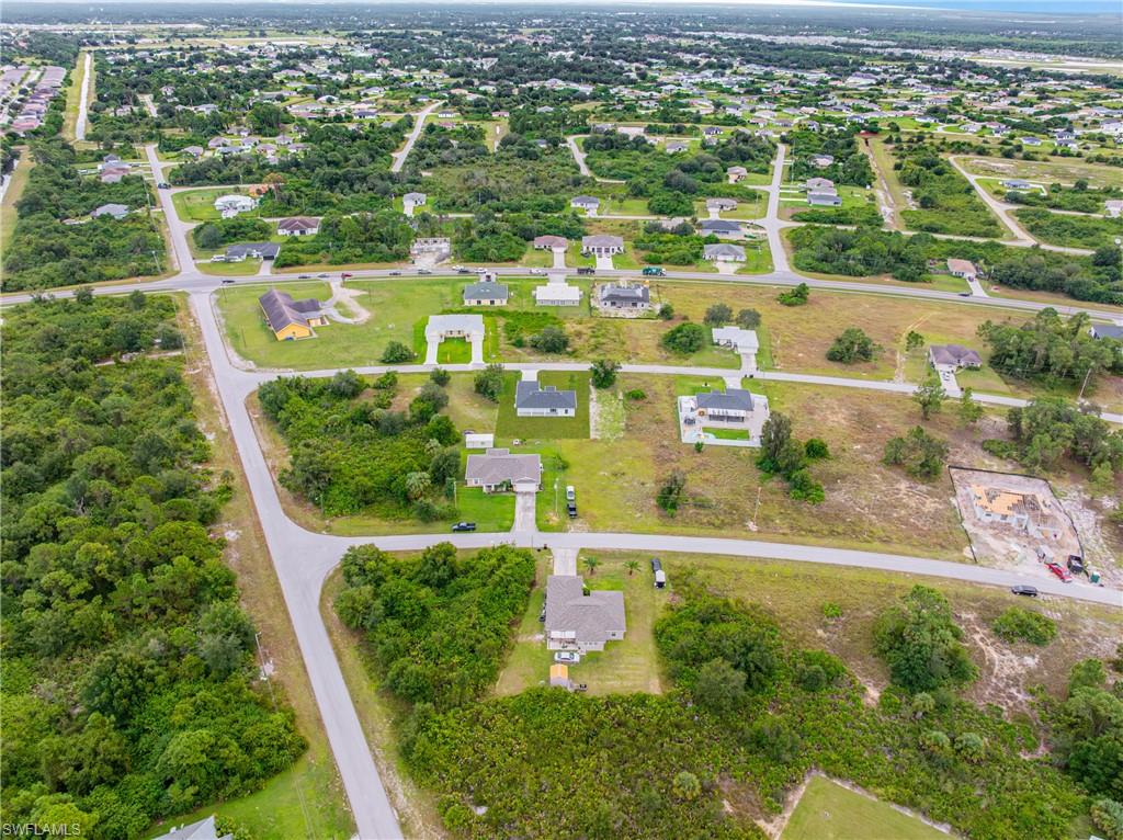343 Pullman Street Lehigh Acres, FL 33974 - Photo 41 of 43 an aerial view of residential houses with outdoor space and trees