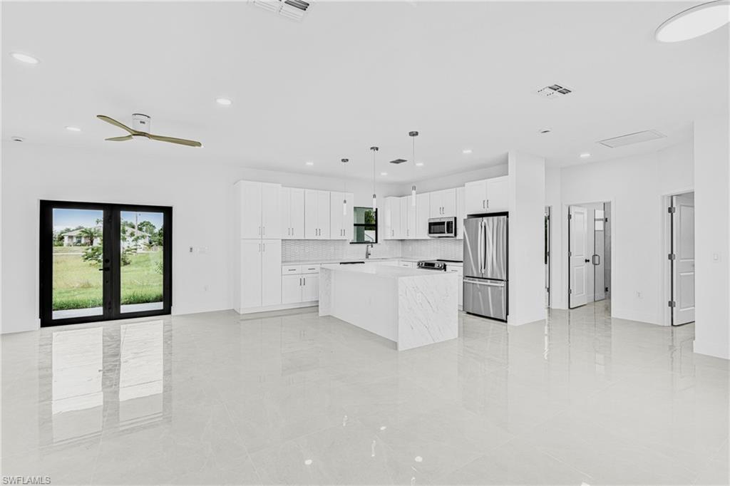 343 Pullman Street Lehigh Acres, FL 33974 - Photo 9 of 43 a large white kitchen with white cabinets and refrigerator