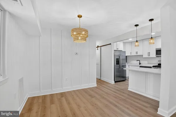 a kitchen with stainless steel appliances granite countertop a refrigerator a stove and a wooden floors