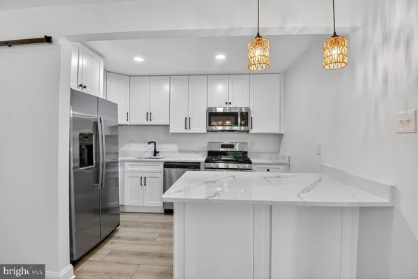 a kitchen with a sink a microwave a stove and refrigerator