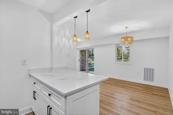 a kitchen with a stove and a wooden floor