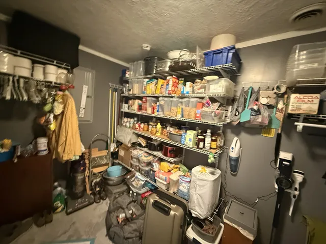 a kitchen with granite countertop a stove a sink a refrigerator and wooden cabinets