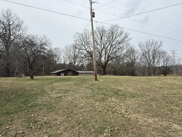 a view of a field with trees in background