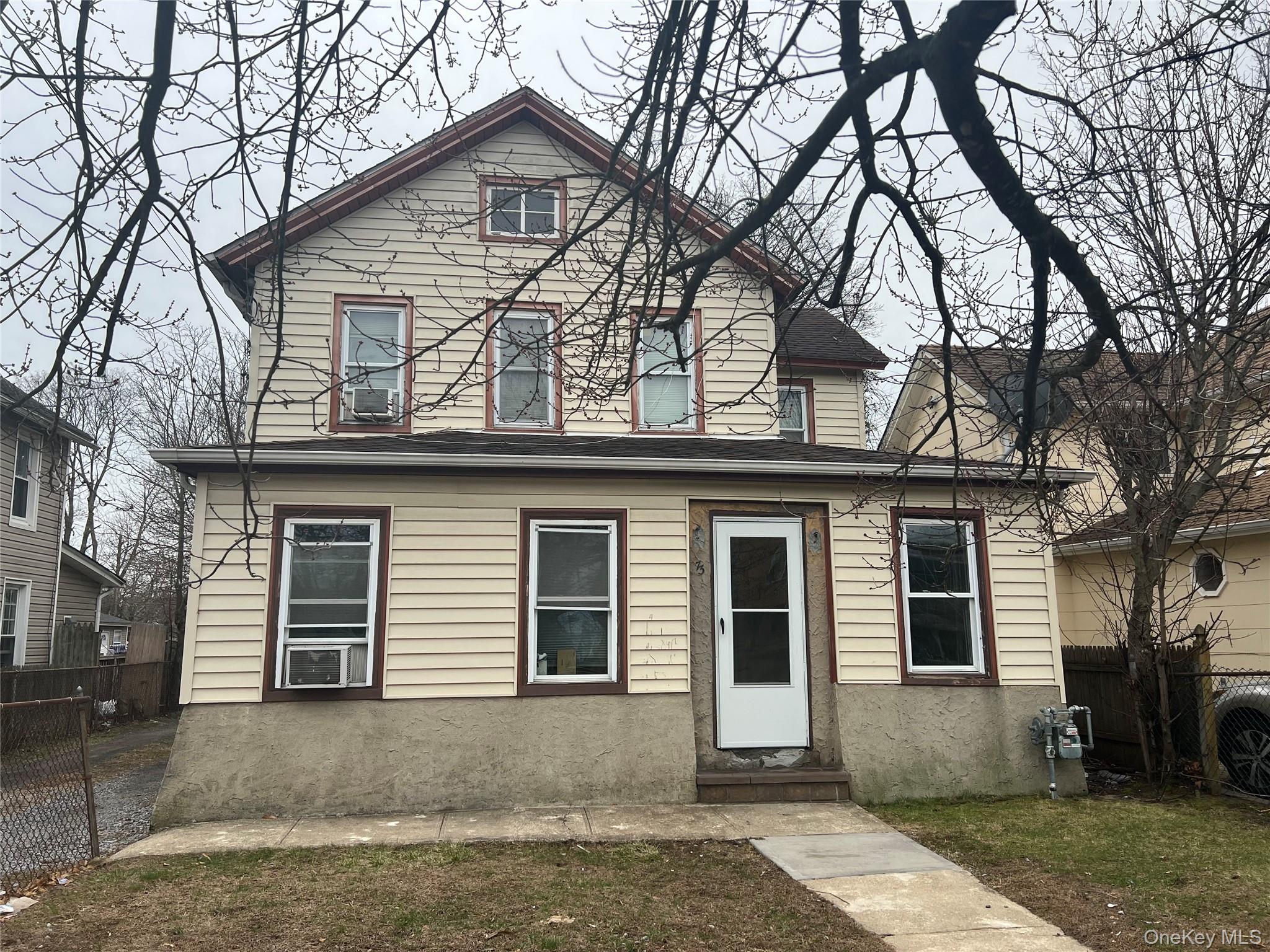 a view of a house with a yard and large tree