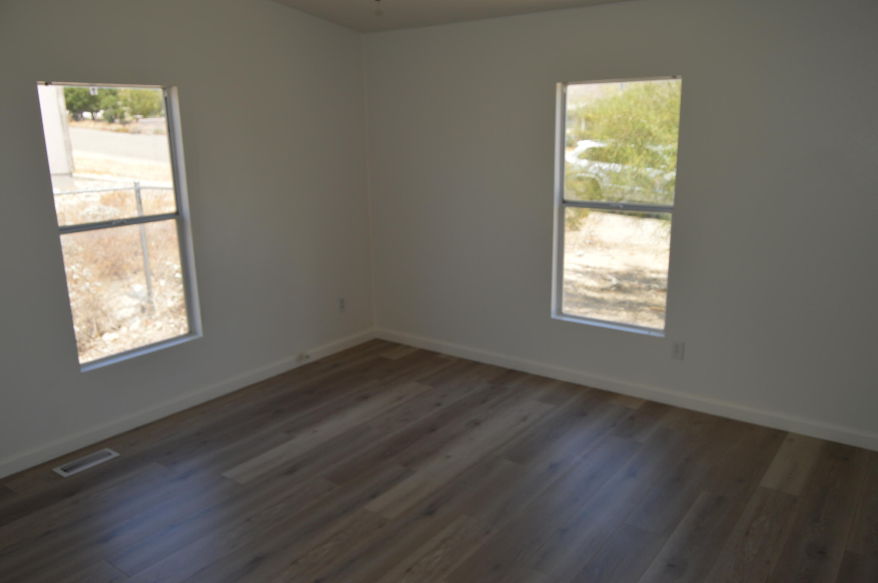 13139 Zane Way Whitewater, CA 92282 - Photo 11 of 12 an empty room with wooden floor and windows