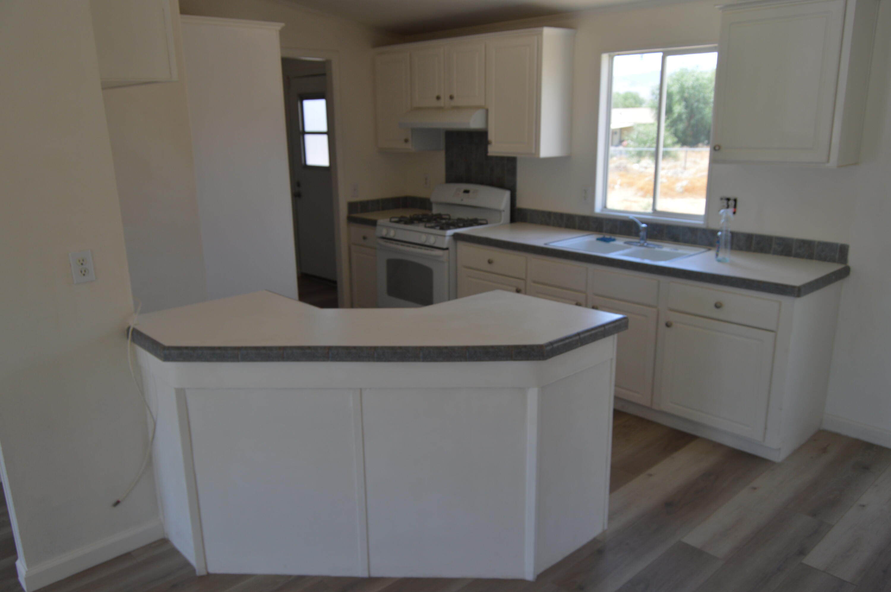 13139 Zane Way Whitewater, CA 92282 - Photo 4 of 12 a kitchen with stainless steel appliances granite countertop a sink stove and microwave
