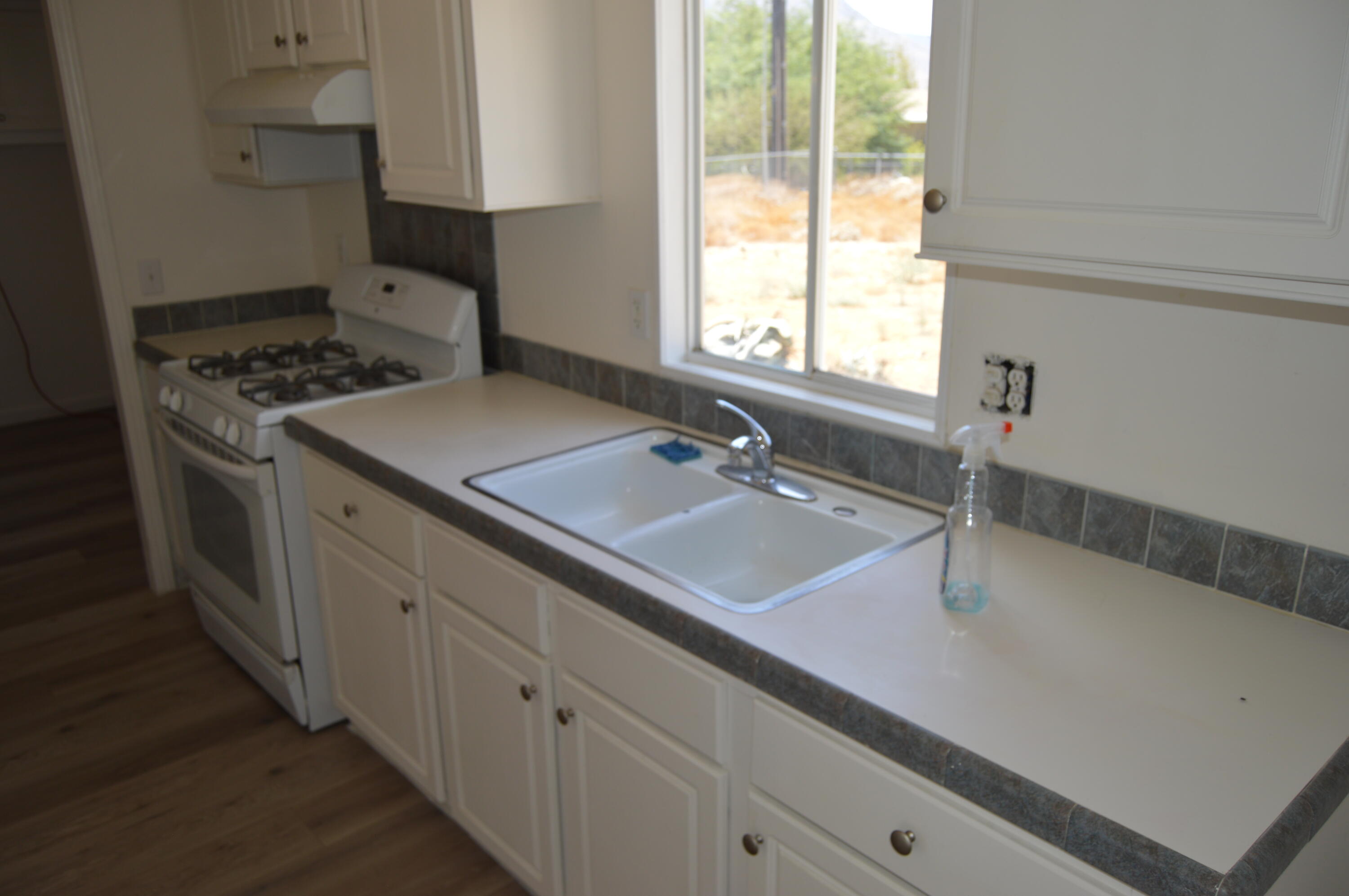 13139 Zane Way Whitewater, CA 92282 - Photo 5 of 12 a kitchen with a sink stove and cabinets