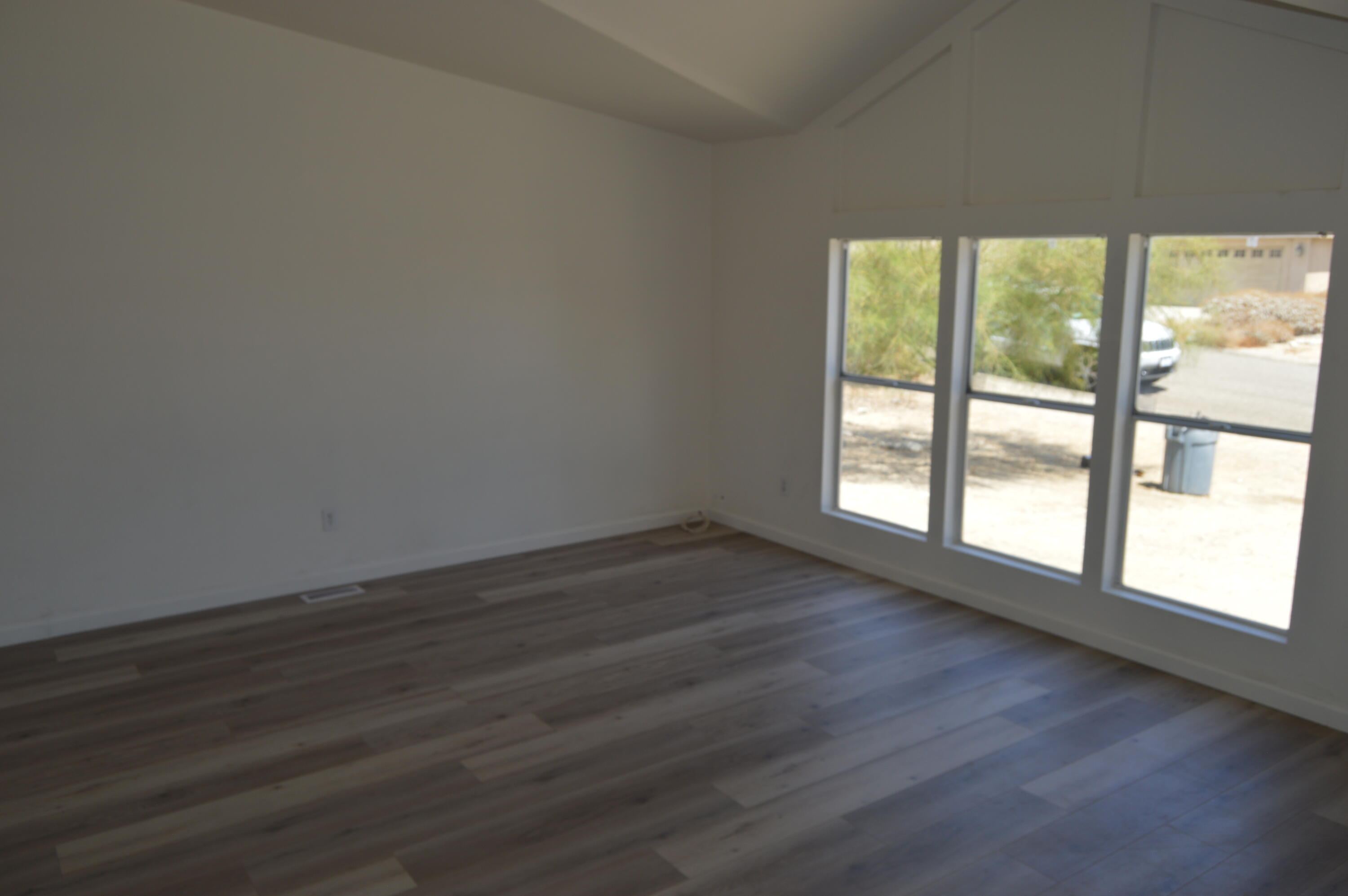 13139 Zane Way Whitewater, CA 92282 - Photo 6 of 12 a view of an empty room with wooden floor and a window