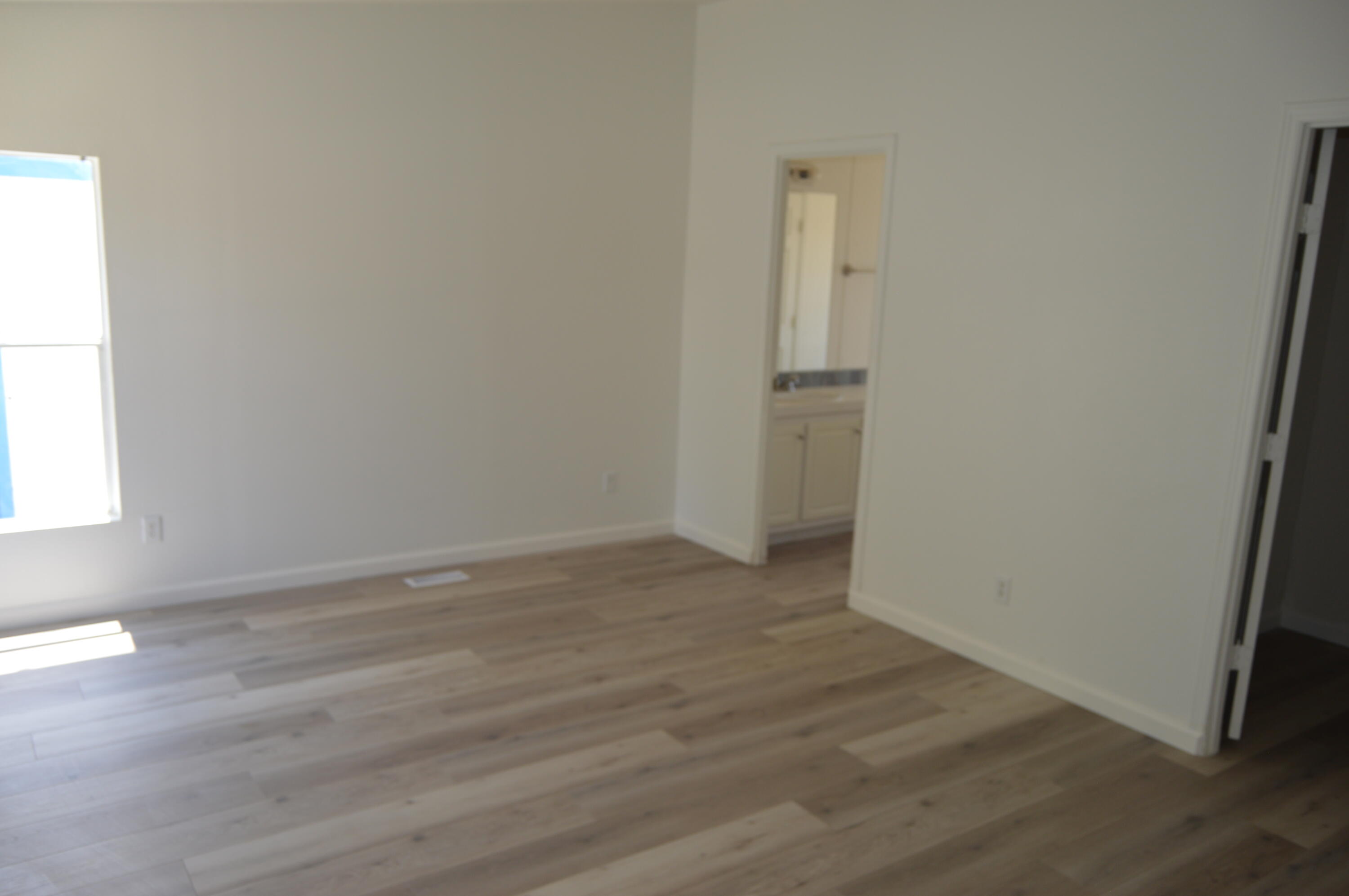 13139 Zane Way Whitewater, CA 92282 - Photo 7 of 12 an empty room with wooden floor and windows