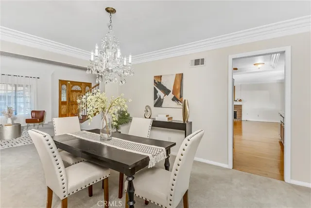 a view of a dining room with furniture and chandelier