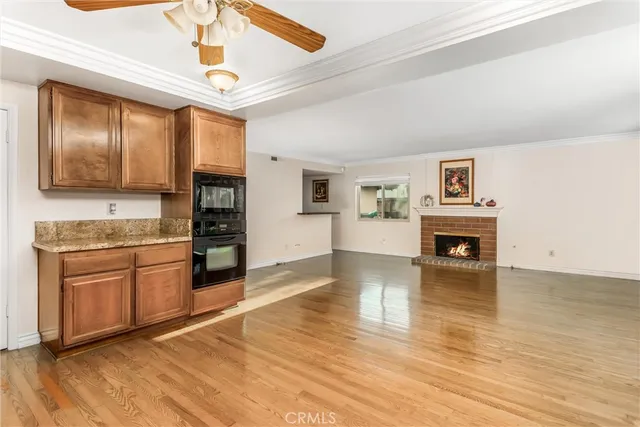 a kitchen with granite countertop a stove top oven a sink dishwasher a dining table and chairs with wooden floor