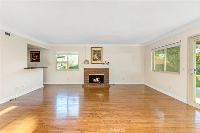 a view of a livingroom with wooden floor and a fireplace
