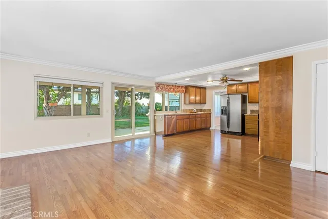 a view of an empty room with window and wooden floor