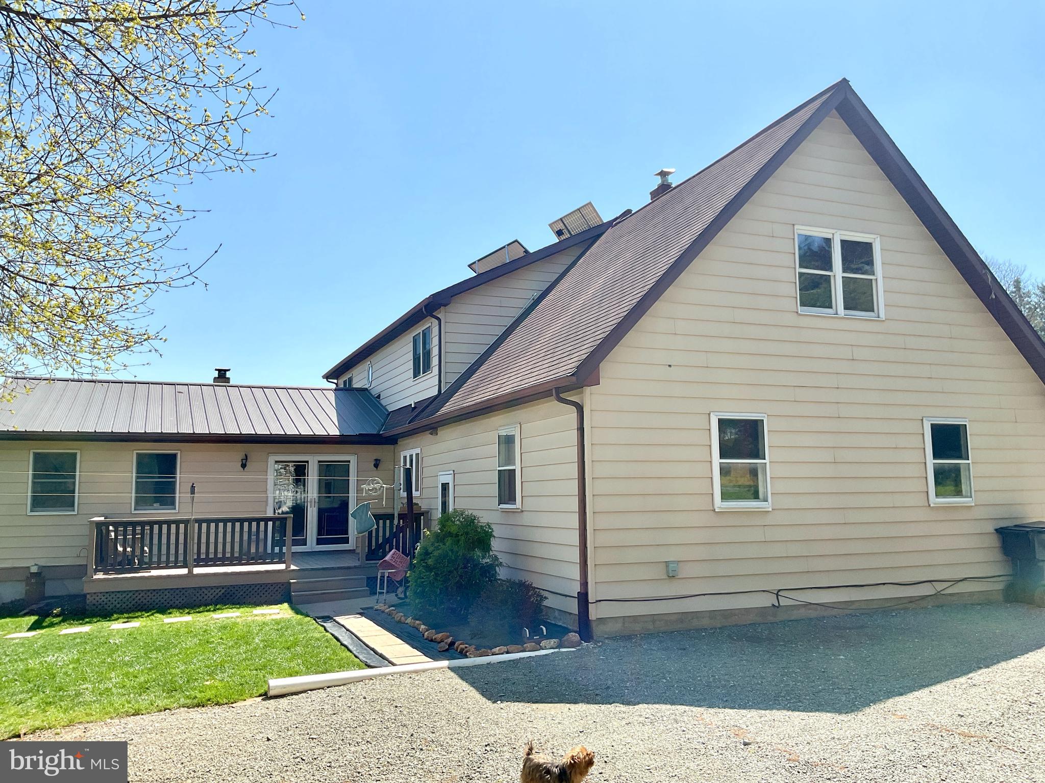 69 Fairview Road New Providence, PA 17560 - Photo 31 of 59 a view of a white house with a yard potted plants and a large tree