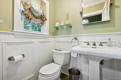 a bathroom with a toilet a sink and mirror