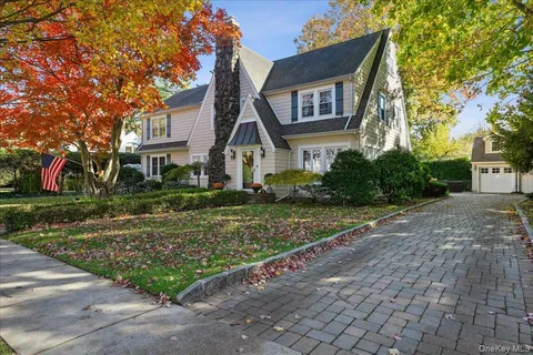 a front view of a house with a yard and potted plants