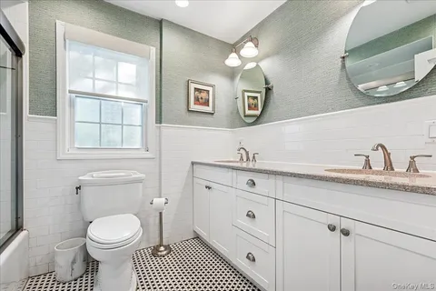 a bathroom with a granite countertop toilet sink and mirror