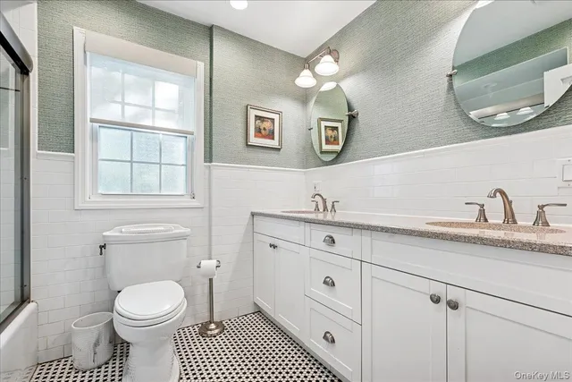 a bathroom with a granite countertop toilet sink and mirror
