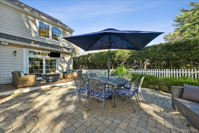 a patio with a table and chairs under an umbrella