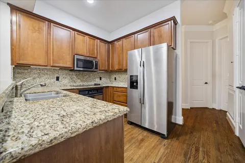 a kitchen with stainless steel appliances granite countertop a refrigerator a stove top oven a sink and dishwasher
