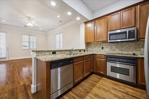 a kitchen with stainless steel appliances granite countertop a stove microwave and sink