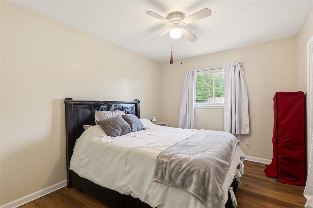 1803 Sycamore Street Commerce, TX 75428 - Photo 11 of 18 a bedroom with a bed and a chandelier
