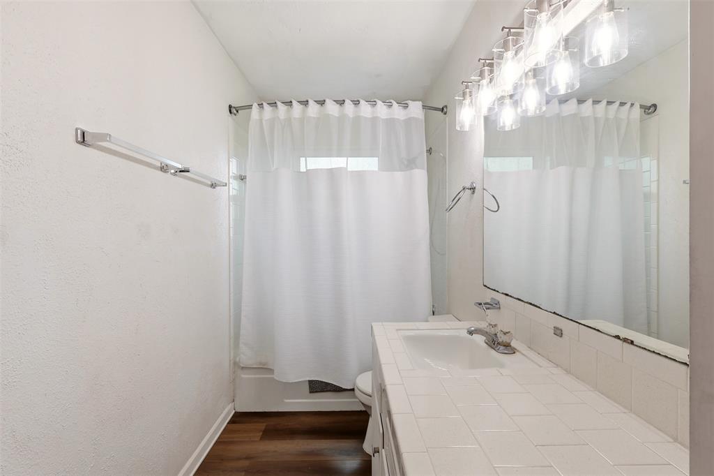 1803 Sycamore Street Commerce, TX 75428 - Photo 12 of 18 a bathroom with a sink and a mirror