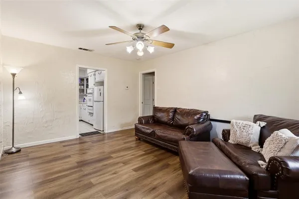 a living room with furniture and wooden floor