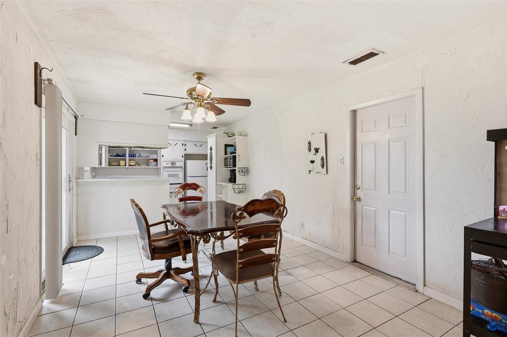 1803 Sycamore Street Commerce, TX 75428 - Photo 7 of 18 a dining room with furniture and a chandelier fan