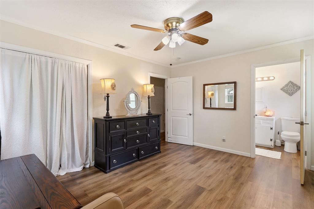 1803 Sycamore Street Commerce, TX 75428 - Photo 8 of 18 a bedroom with a bed and wooden floor