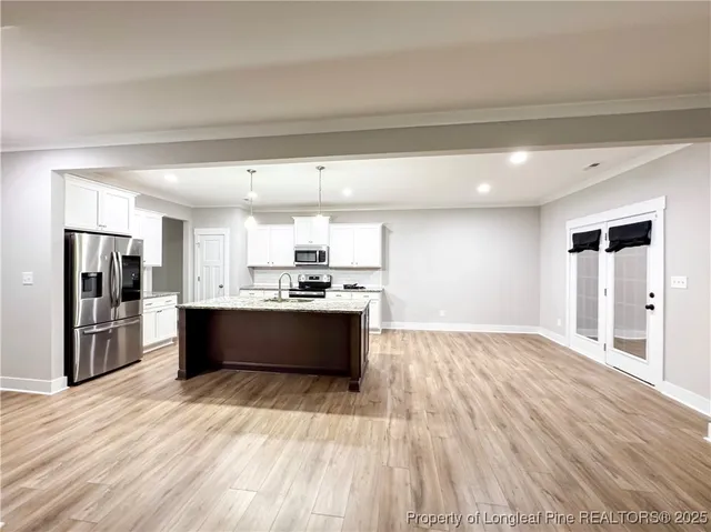 a large kitchen with stainless steel appliances kitchen island wooden cabinets and granite counter tops