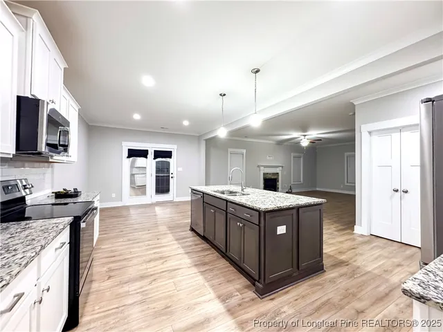 a kitchen with stainless steel appliances granite countertop wooden floors and view living room