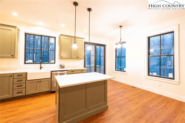 a kitchen with stainless steel appliances sink stove and wooden floor