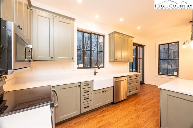 a large kitchen with stainless steel appliances granite countertop a stove and a sink