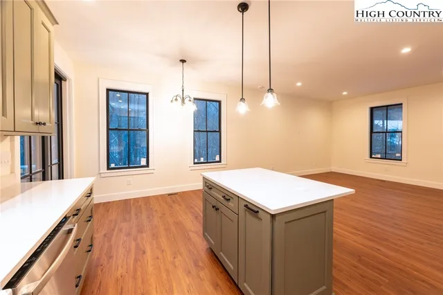a kitchen with a sink and wooden floor
