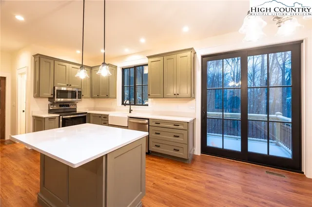 a kitchen with a refrigerator a sink and wooden floor