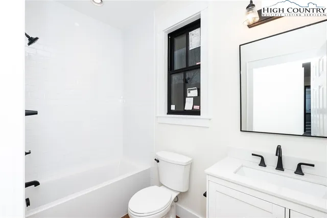 a bathroom with a toilet sink vanity tub and shower