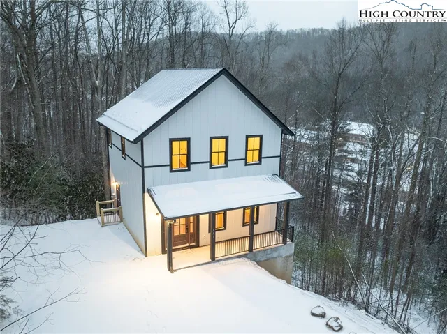 a view of a house with a yard and large trees