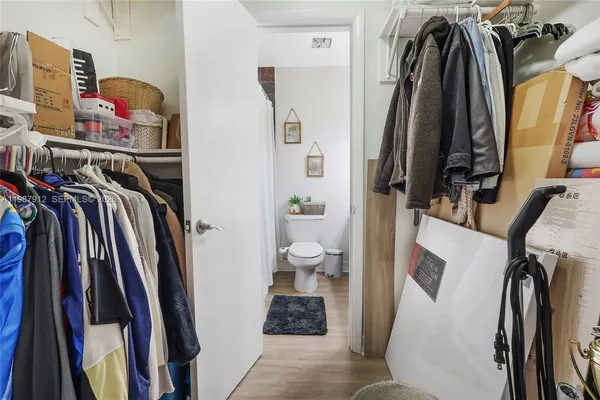 a view of walk in closet with clothes and shoes