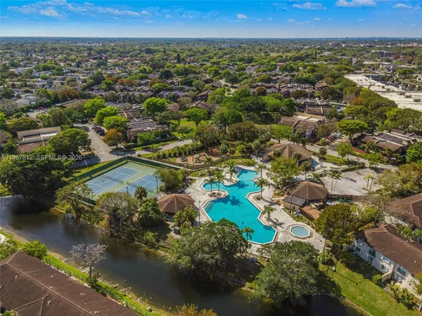 an aerial view of residential houses with outdoor space and trees