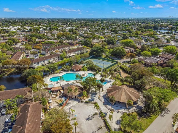 an aerial view of residential houses with outdoor space and trees