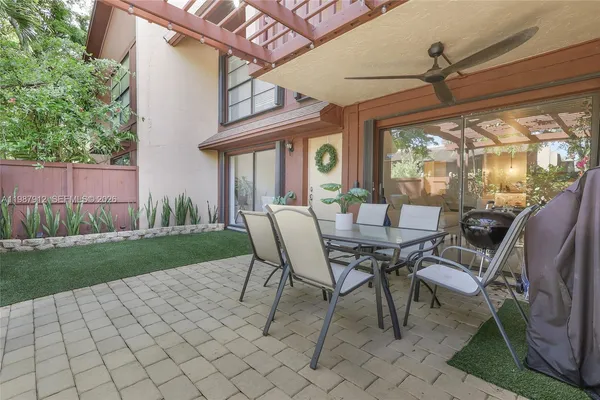 a view of a patio with a table chairs and a backyard