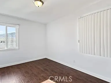 a view of a room with wooden floor and windows