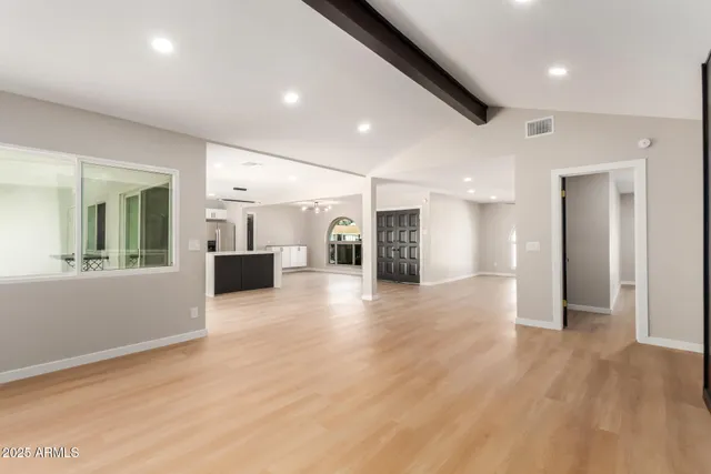 a large kitchen with stainless steel appliances granite countertop a refrigerator a stove a sink dishwasher a microwave oven with cabinets and wooden floor