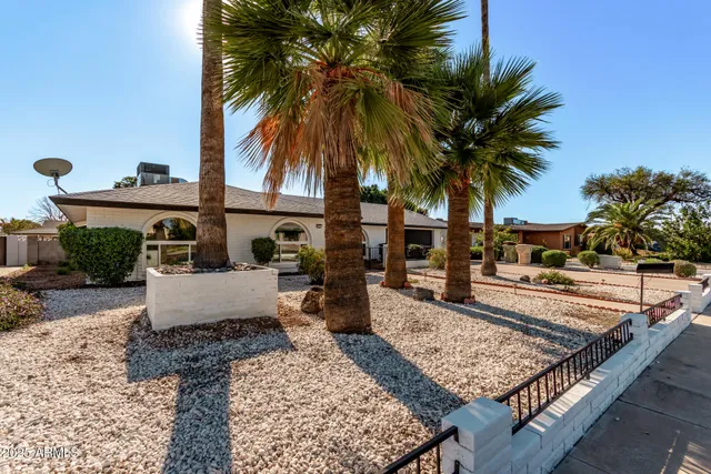 front view of a house with palm trees