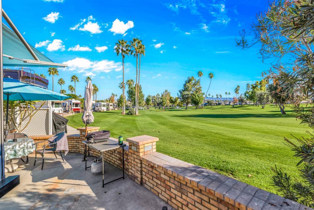 69411 Ramon Road, Unit 776 Cathedral City, CA 92234 - Photo 3 of 17 a backyard of a house with barbeque oven table and chairs